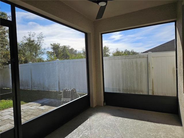 unfurnished sunroom featuring ceiling fan