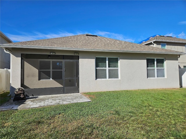 rear view of property with a patio area, a sunroom, and a yard