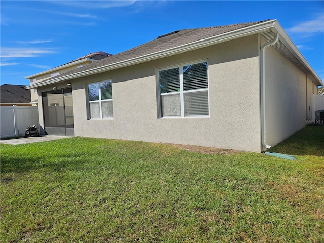 back of house with a lawn and a patio