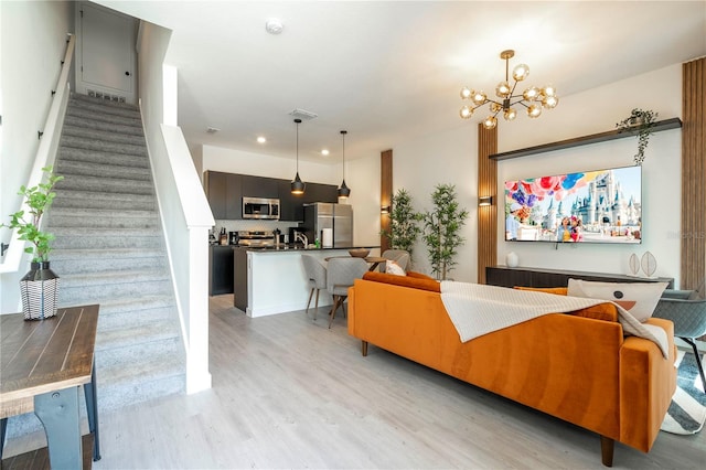 living room with a chandelier and light wood-type flooring