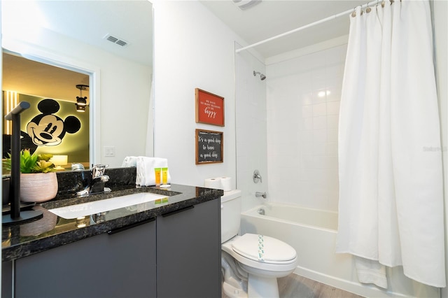 full bathroom featuring shower / bath combo with shower curtain, hardwood / wood-style floors, vanity, and toilet