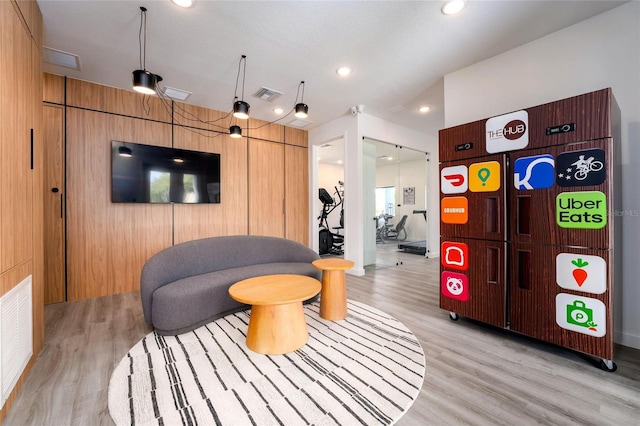 living room featuring wood walls and light hardwood / wood-style flooring