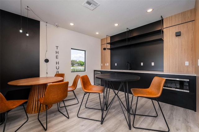 interior space with light hardwood / wood-style floors, sink, and beverage cooler