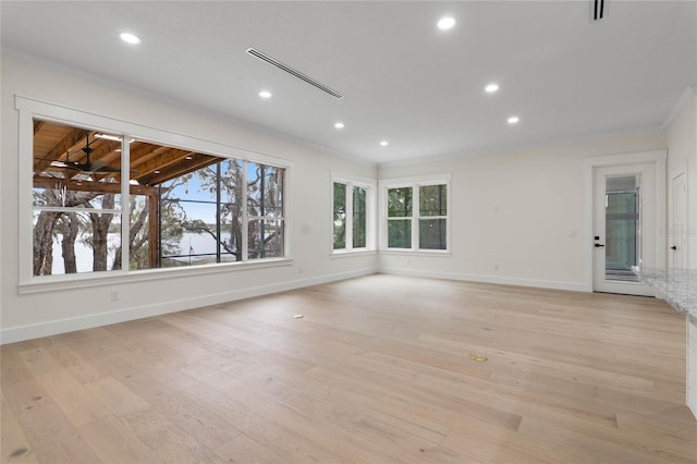 spare room with crown molding, recessed lighting, baseboards, and light wood finished floors