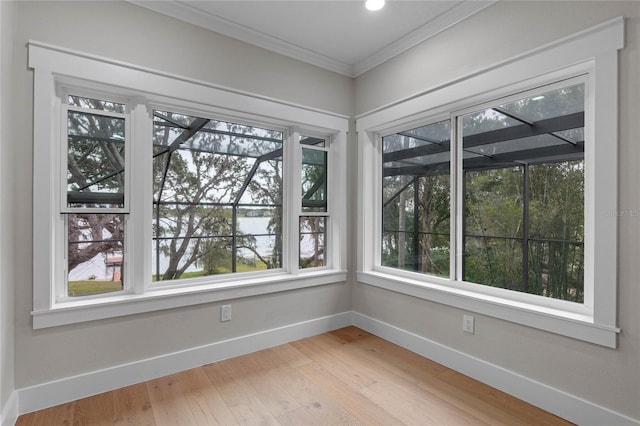 interior space featuring hardwood / wood-style flooring, a healthy amount of sunlight, and ornamental molding