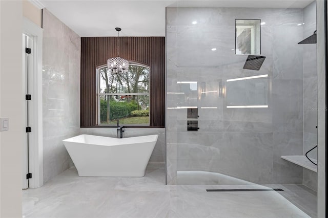 bathroom featuring plus walk in shower and tile walls