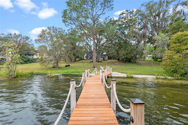 dock area with a water view and a lawn