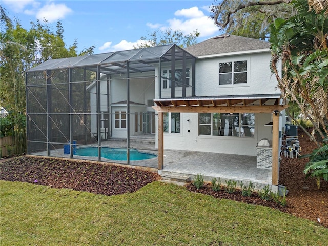 back of property with a patio area, stucco siding, a lanai, and a lawn