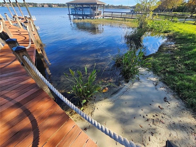 dock area featuring fence and a water view