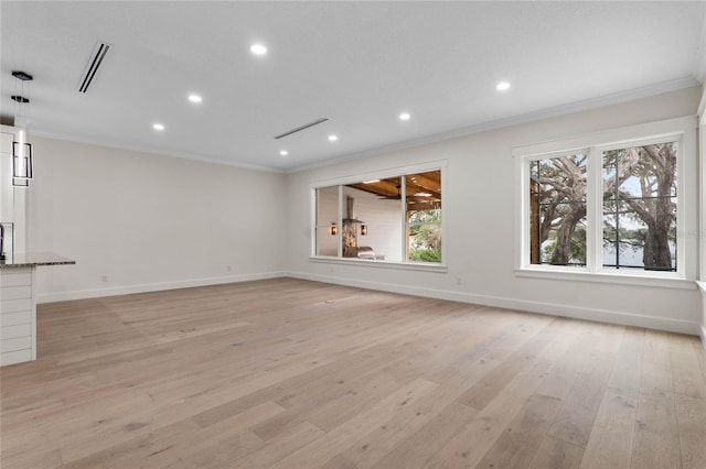 unfurnished living room with light wood-type flooring, baseboards, visible vents, and ornamental molding