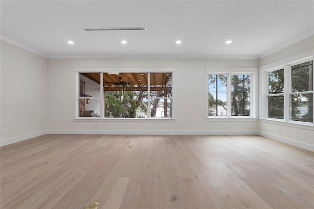 spare room featuring baseboards, light wood-style floors, and crown molding