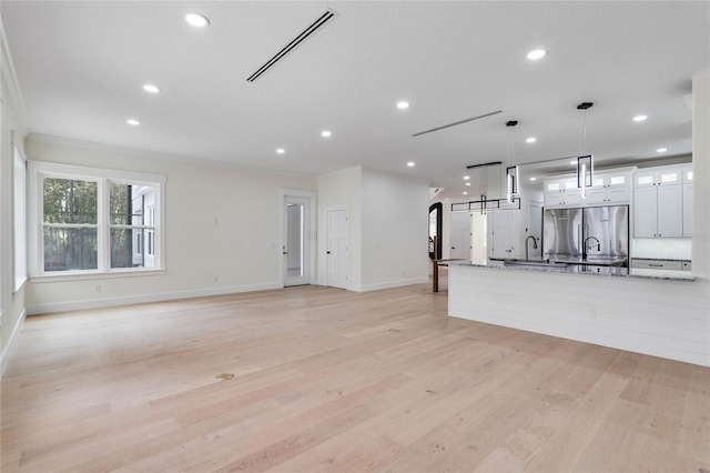 unfurnished living room with visible vents, baseboards, light wood-type flooring, ornamental molding, and recessed lighting