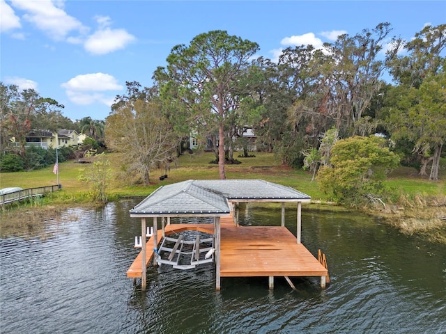 view of dock featuring a yard, a water view, and boat lift