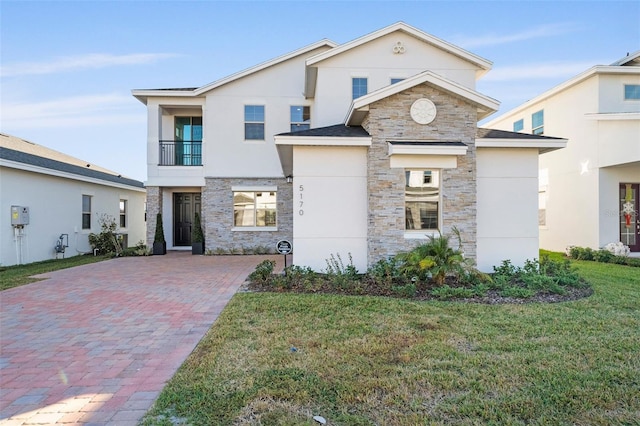 view of front of property with a balcony and a front lawn