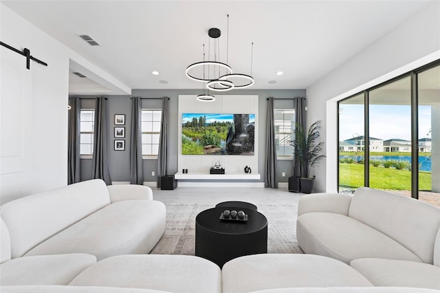 living room featuring a chandelier and a barn door