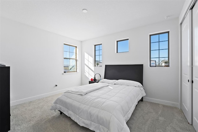 bedroom with light carpet and a closet