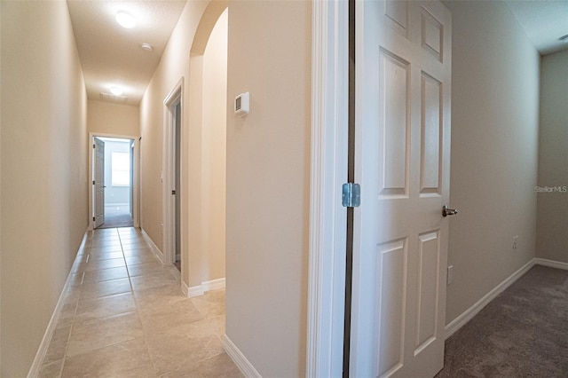 hall with light tile patterned floors