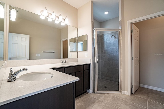 bathroom featuring tile patterned flooring, vanity, and walk in shower