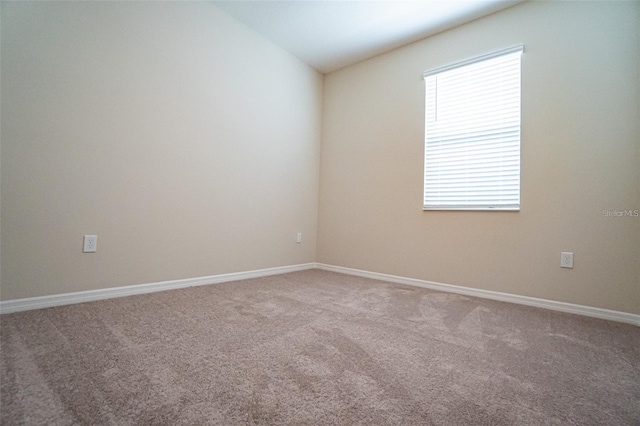 carpeted spare room with vaulted ceiling