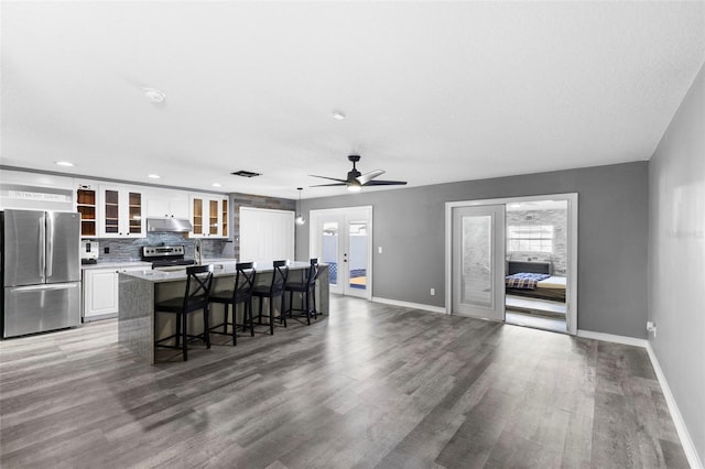 kitchen featuring french doors, white cabinets, hardwood / wood-style flooring, a kitchen island, and stainless steel appliances