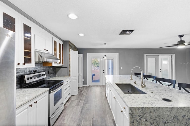 kitchen featuring sink, stainless steel appliances, pendant lighting, white cabinets, and light wood-type flooring