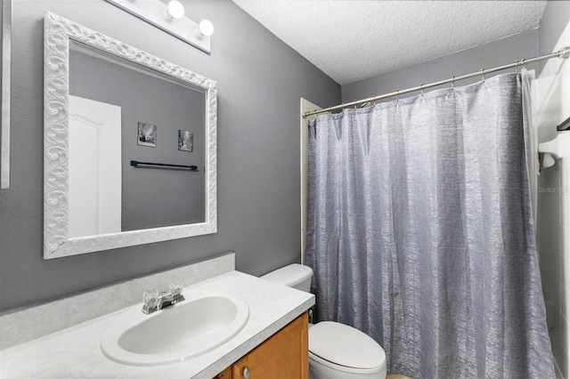 bathroom featuring walk in shower, vanity, a textured ceiling, and toilet