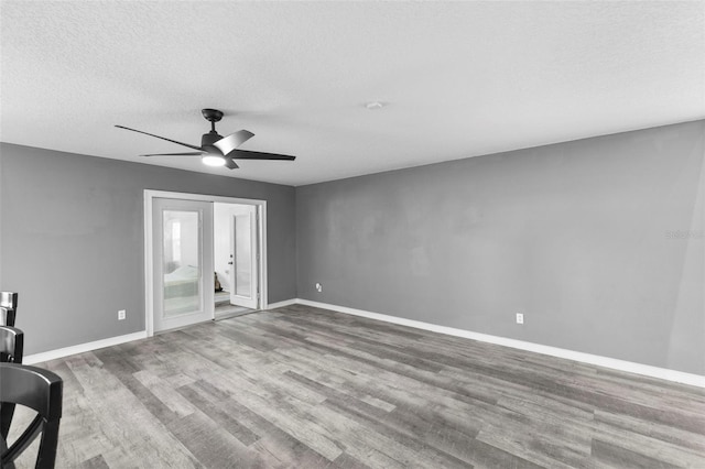 spare room featuring a textured ceiling, ceiling fan, hardwood / wood-style floors, and french doors