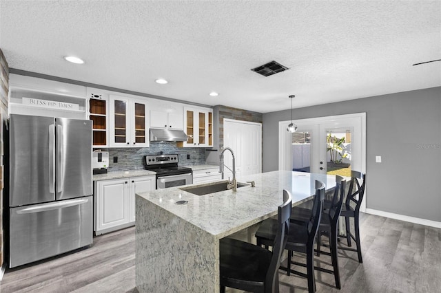 kitchen featuring sink, french doors, hanging light fixtures, wood-type flooring, and appliances with stainless steel finishes