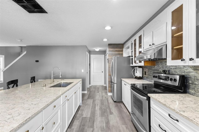 kitchen featuring white cabinetry, sink, light hardwood / wood-style floors, and appliances with stainless steel finishes