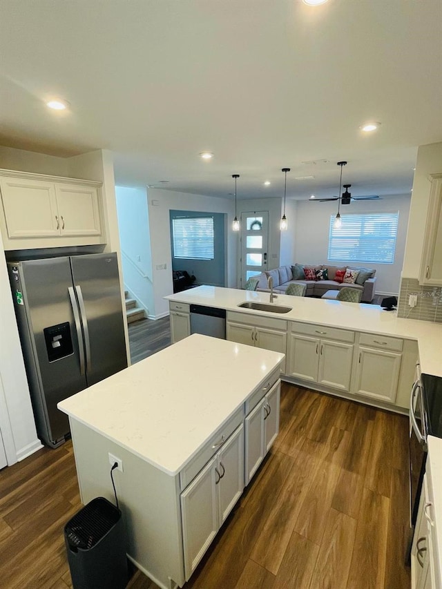 kitchen with kitchen peninsula, appliances with stainless steel finishes, a wealth of natural light, and sink