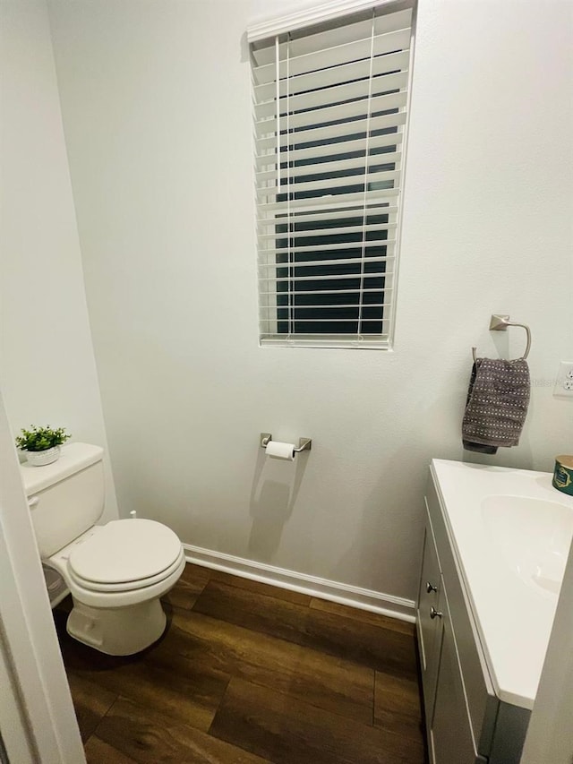 bathroom with hardwood / wood-style floors, vanity, and toilet