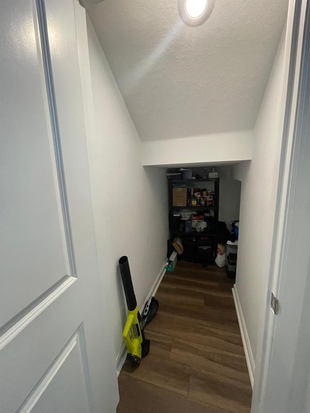 corridor featuring a textured ceiling and dark hardwood / wood-style floors