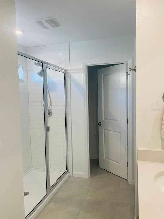 bathroom with tile patterned floors, vanity, and a shower with shower door