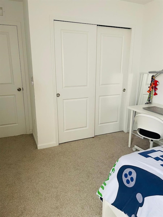 bedroom featuring light carpet and a closet