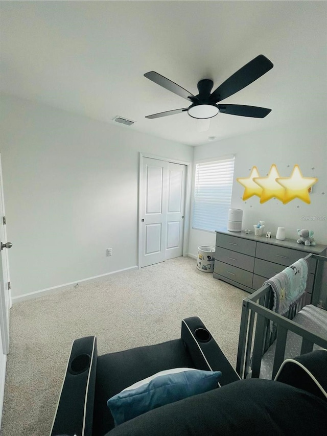 carpeted bedroom with ceiling fan and a closet