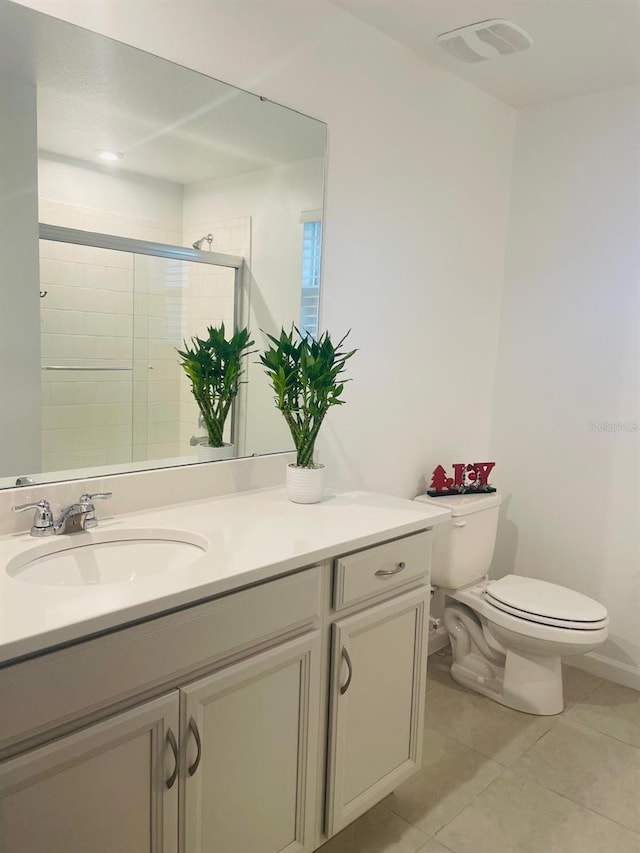 bathroom featuring toilet, tile patterned flooring, vanity, and walk in shower