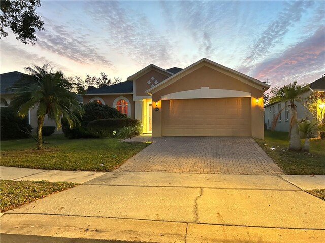 view of front of property featuring a garage and a lawn