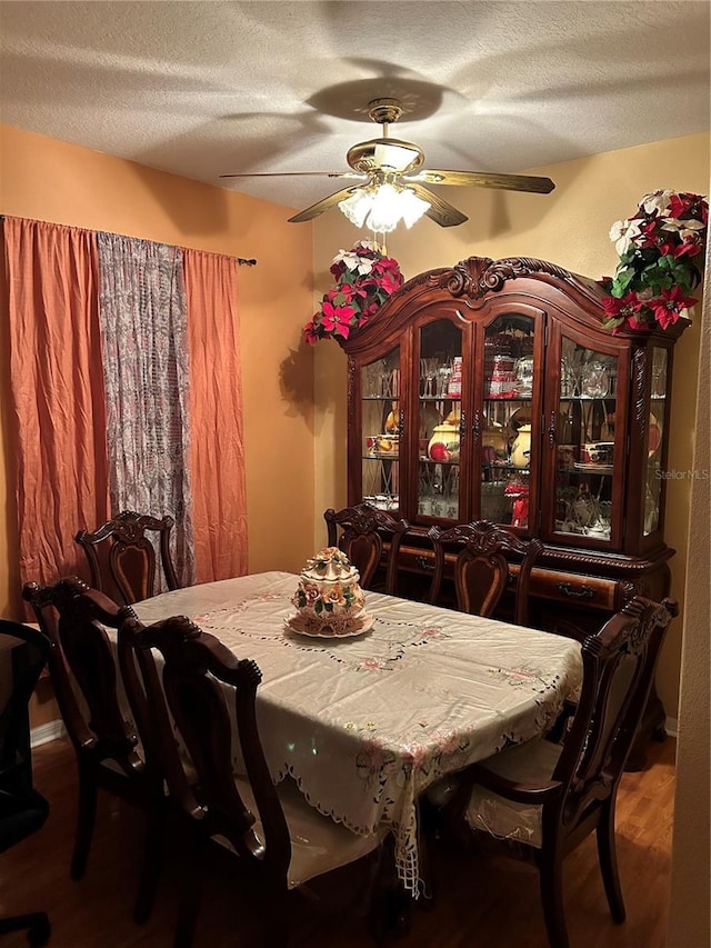 dining room with hardwood / wood-style flooring, ceiling fan, and a textured ceiling