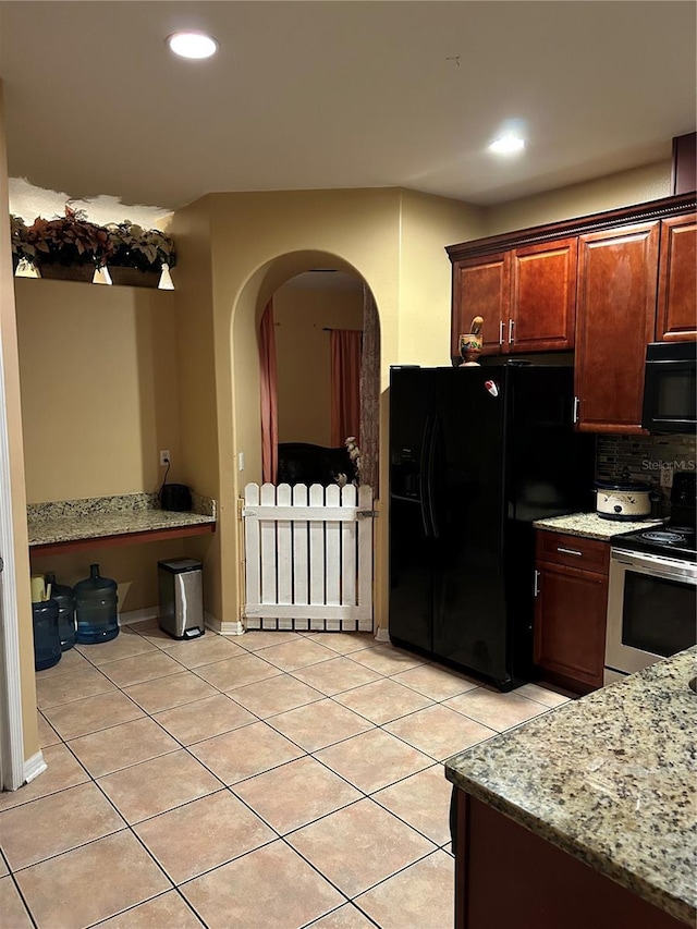 kitchen with black appliances, decorative backsplash, light stone countertops, and light tile patterned floors