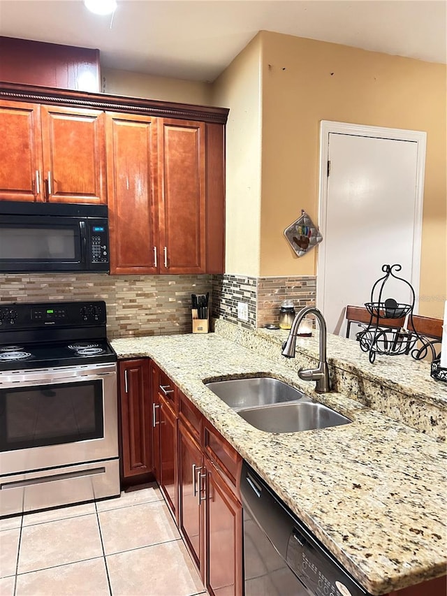 kitchen featuring light stone countertops, backsplash, sink, black appliances, and light tile patterned flooring