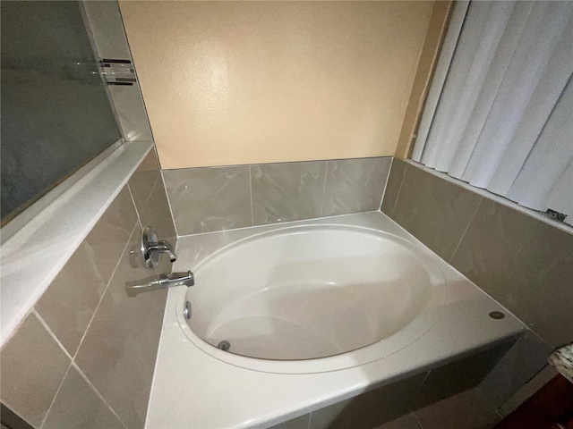 bathroom featuring a washtub and tile walls