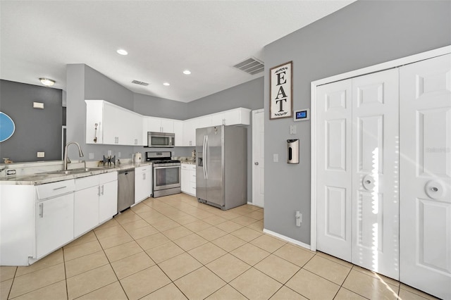 kitchen featuring white cabinetry, sink, light tile patterned flooring, and stainless steel appliances