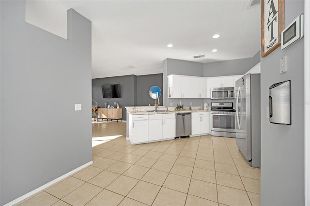 kitchen featuring white cabinetry, sink, stainless steel appliances, kitchen peninsula, and light tile patterned floors