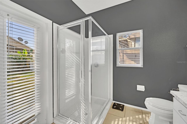 bathroom featuring toilet, vanity, tile patterned floors, and a shower with shower door