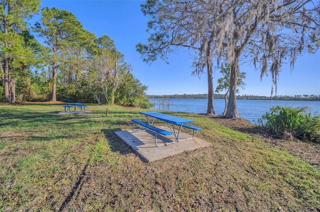 view of property's community with a lawn and a water view