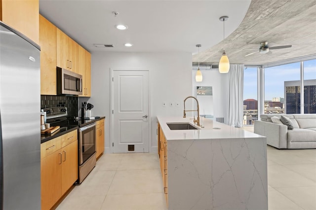 kitchen with backsplash, stainless steel appliances, ceiling fan, sink, and hanging light fixtures