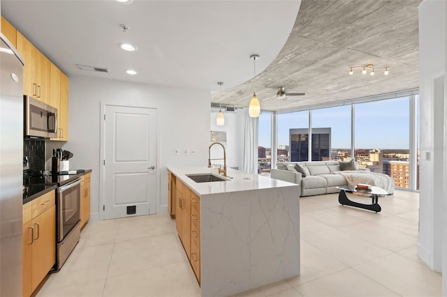 kitchen featuring pendant lighting, sink, ceiling fan, light brown cabinetry, and stainless steel appliances