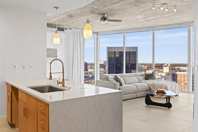 kitchen with ceiling fan, expansive windows, sink, and hanging light fixtures