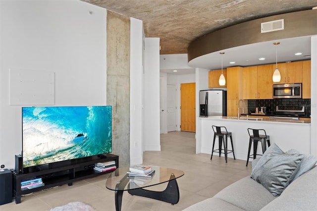 tiled living room featuring sink