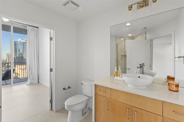 bathroom with tile patterned flooring, vanity, a shower with door, and toilet